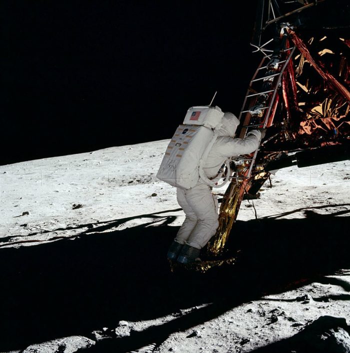 An astronaut climbing down from the Lander to the Moon's surface