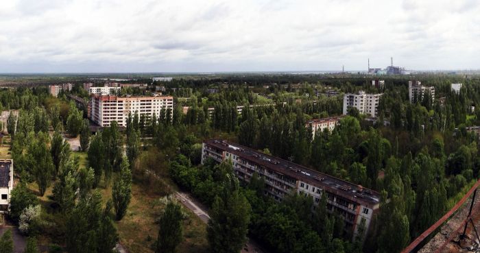The town of Pripyat with Chernobyl power plant in the distance