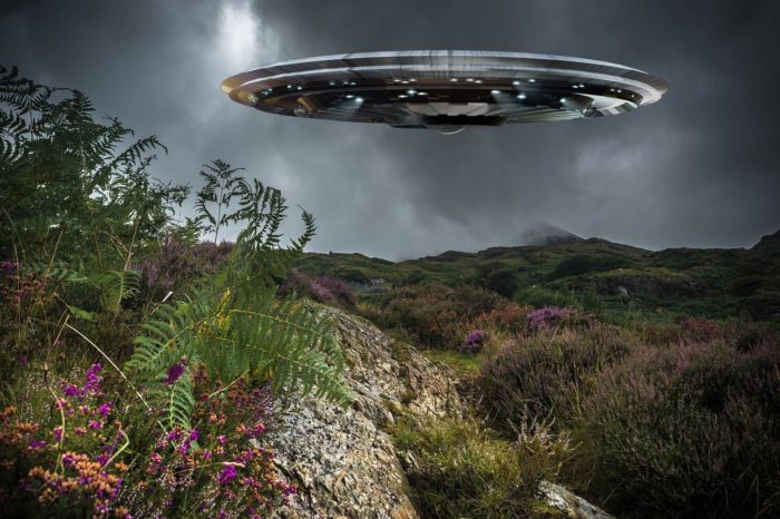 A depiction of a UFO over the countryside