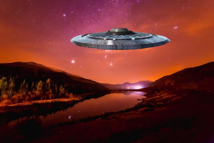 A depiction of a UFO over the countryside