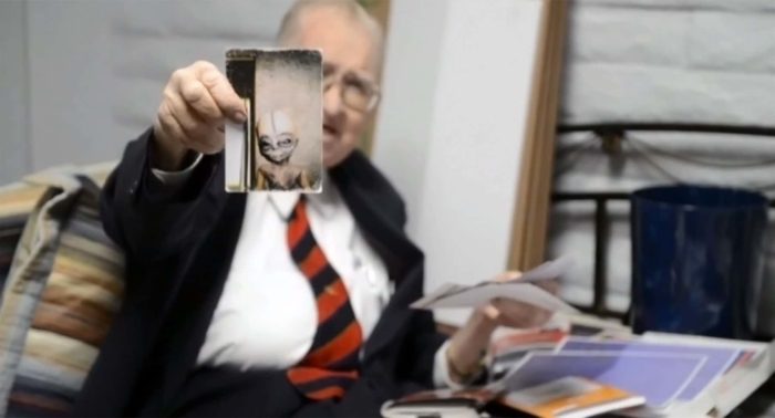 Boyd Bushman holding a photo of an alien life form.
