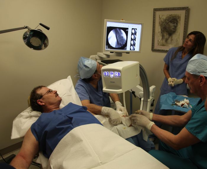 Dr. Leir and team removing an implant from a patient’s hand.