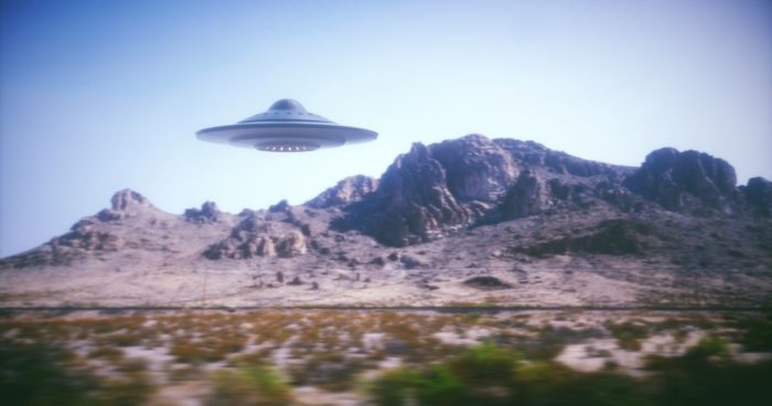 A depiction of a UFO over a mountainous terrain