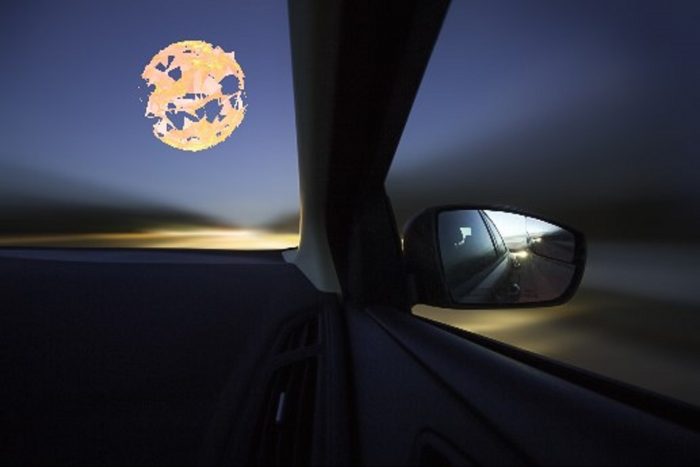 Depiction of a glowing orange orb seen from the inside of a car