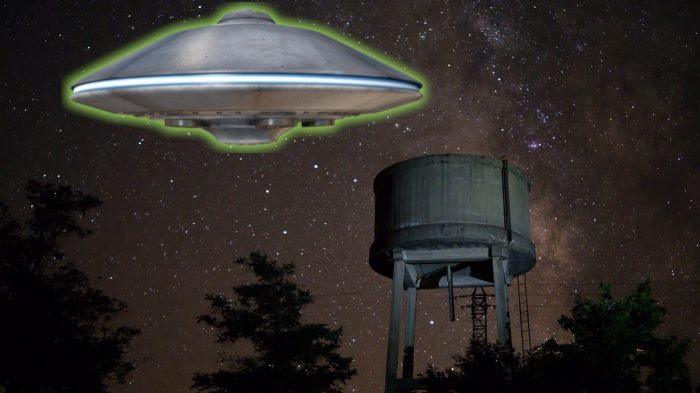 A depiction of a UFO hovering over a water tower