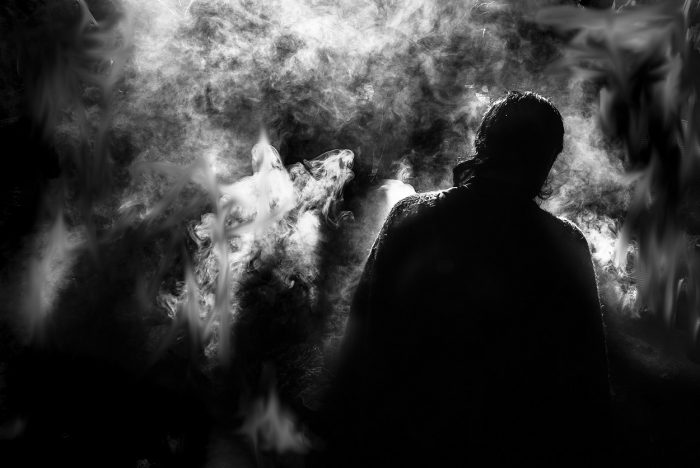 The dark image of man facing away looking into a strange smoky fog