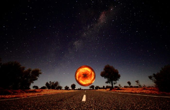 A depiction of a lonely highway with a glowing orb hovering 