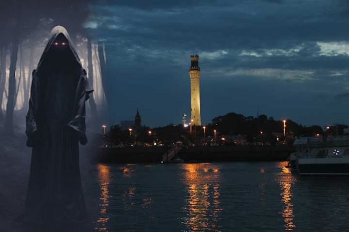 A picture of a black hooded figure blended into a night scene of Provincetown