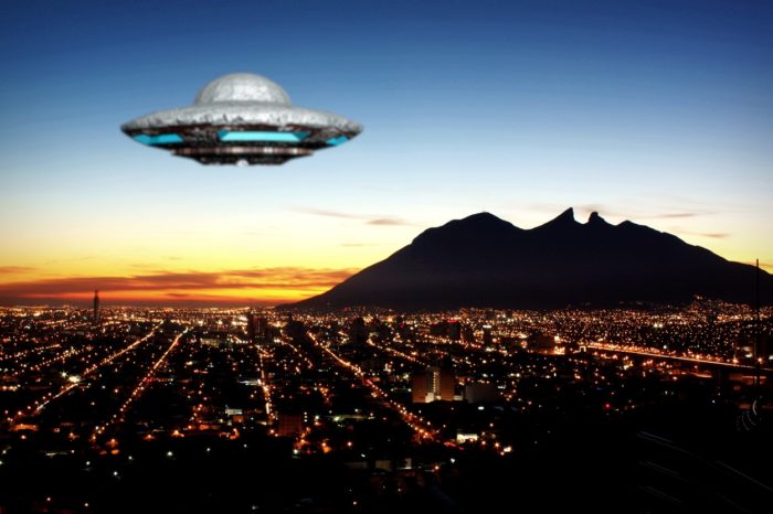 Superimposed UFO over a night city setting