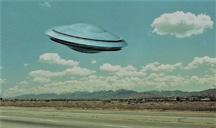 A depiction of a UFO over a lonely road