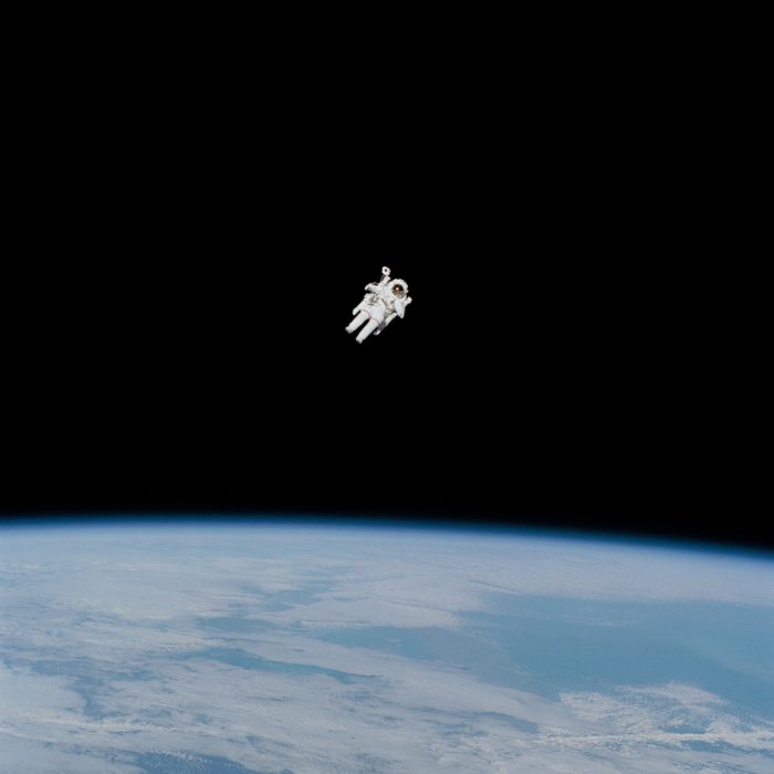 An astronaut floating high above the surface of the Earth