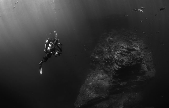 An underwater diver examining an underwater rock
