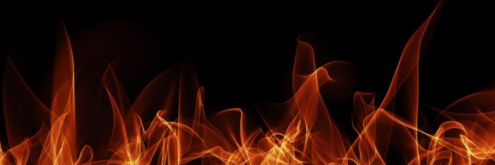 Flames reaching upwards against a black background