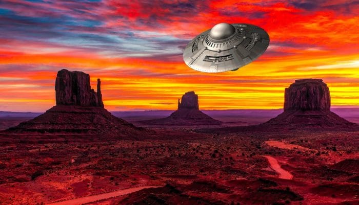 A depiction of a UFO over an Arizona desert at sunset