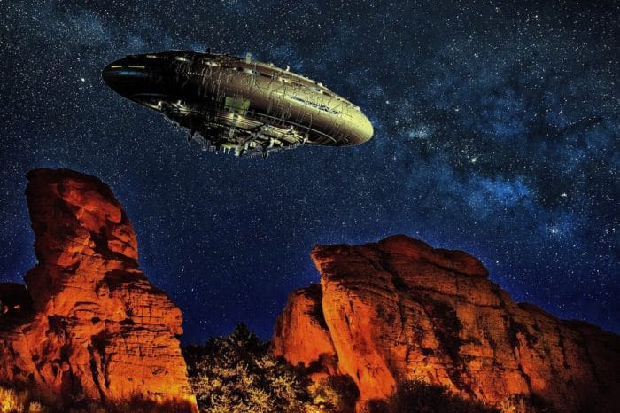 A superimposed UFO over a desert with a night sky