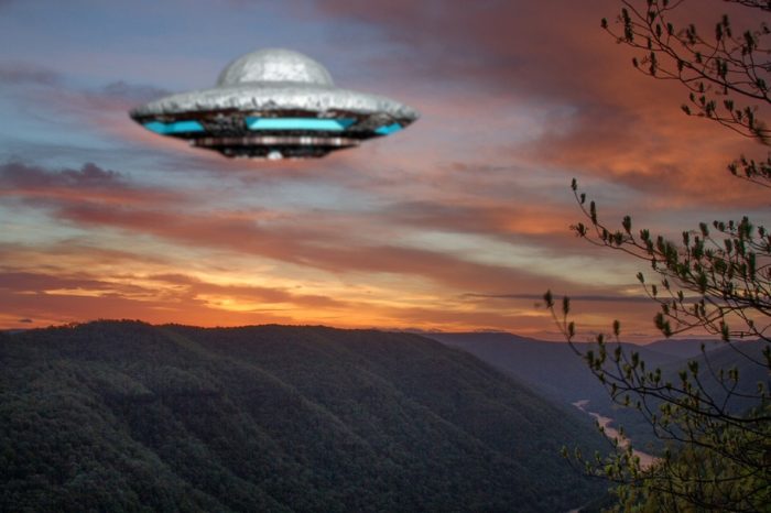 A depiction of a UFO hovering over mountains