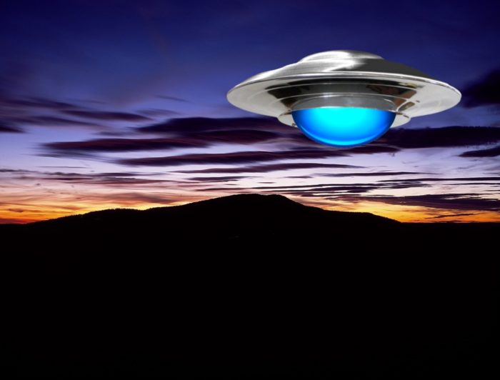 A superimposed UFO over a mountain at night