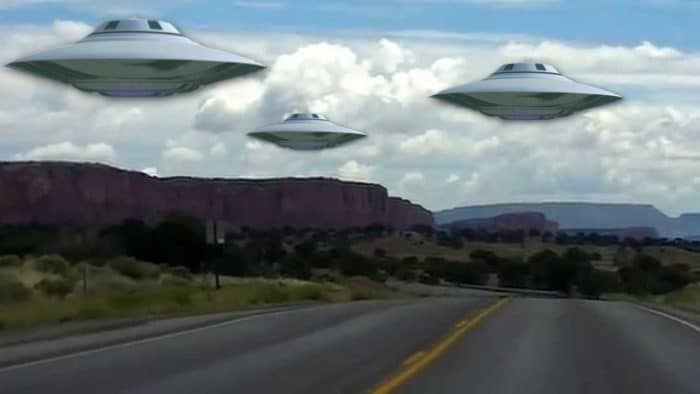 A depiction of UFOs over a New Mexico road