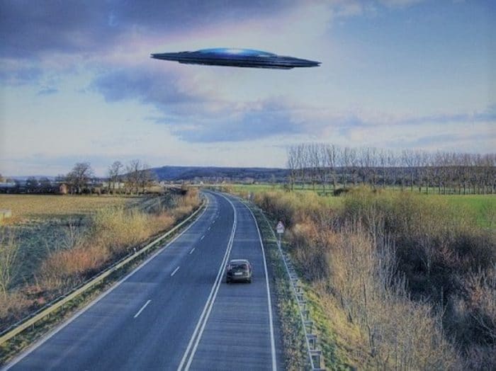 A depiction of a UFO over a road