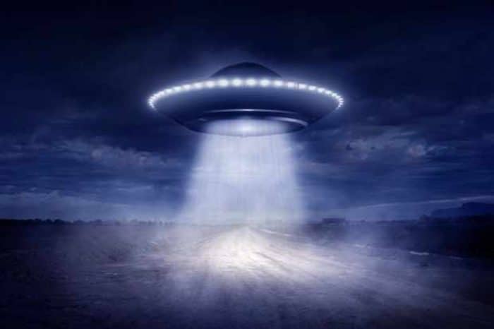 A depiction of a UFO shining a light to the ground