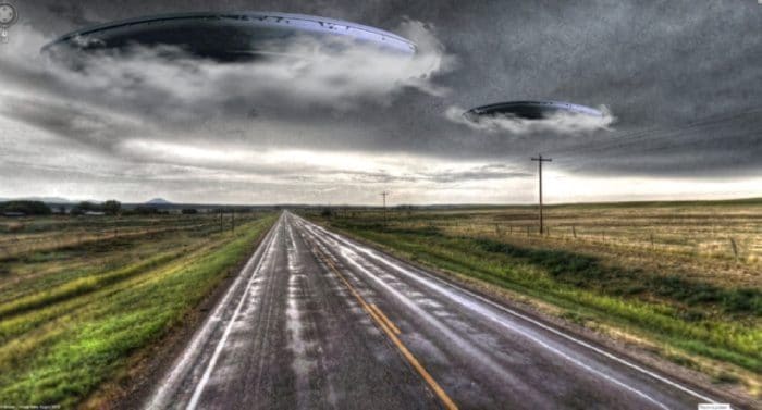 A depiction of a UFO emerging from clouds over a lonely road