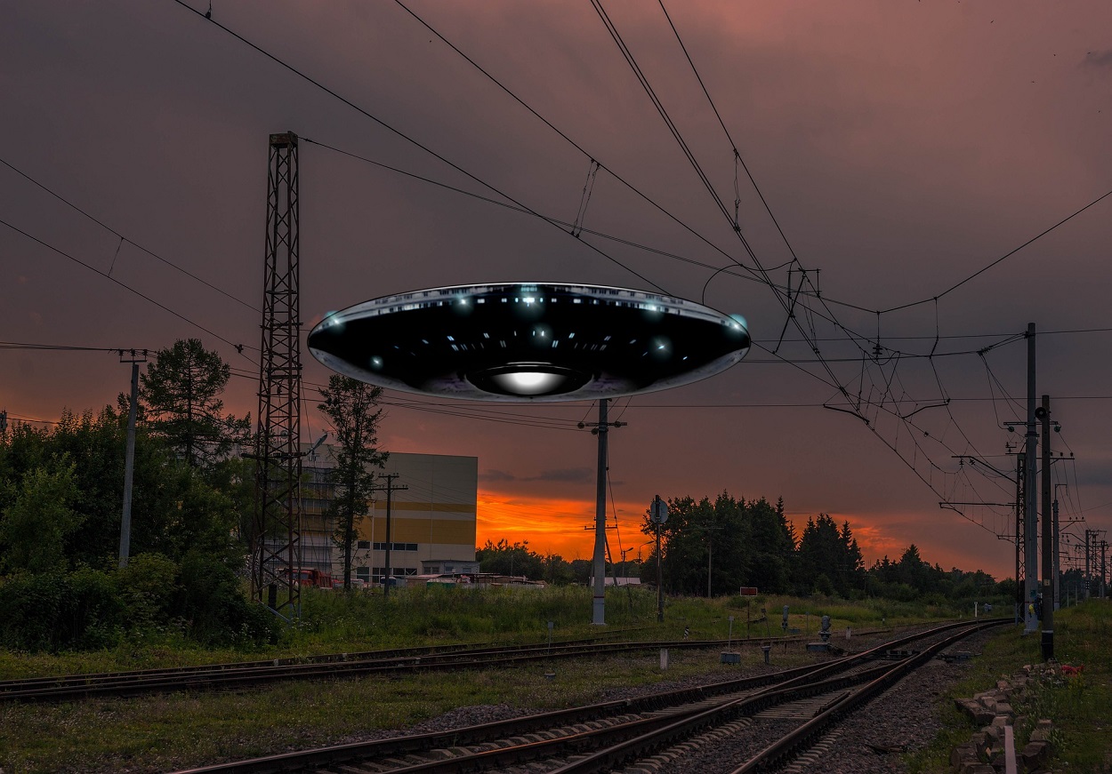 A depiction of a UFO over a rail track