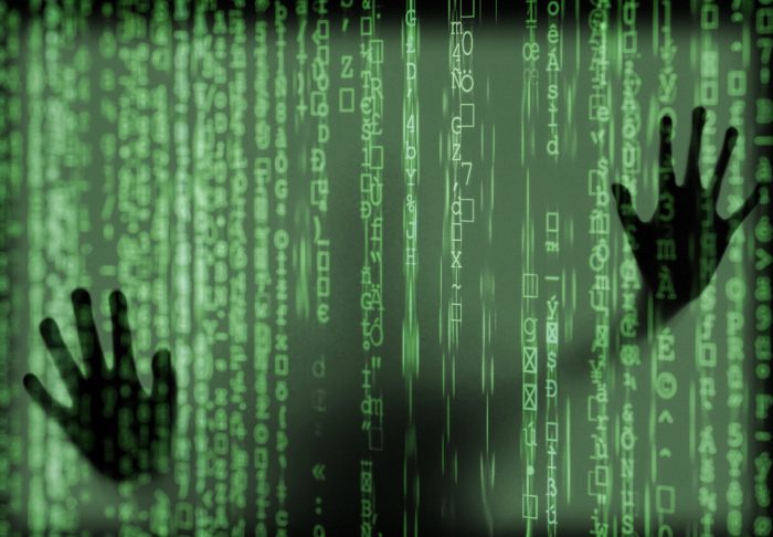 Digital information with a superimposed pair of hands from behind the screen
