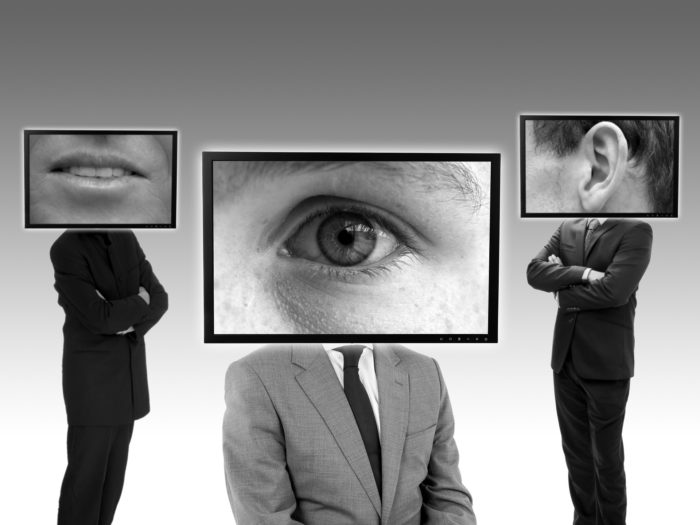 Three people with screens for heads - one with a mouth, one with an eye, one with an ear