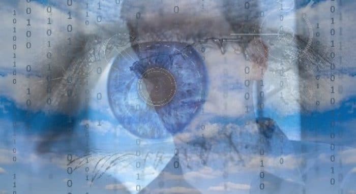 Edward Snowden with a faded picture of an eye in the sky behind him