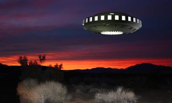 A depiction of a UFO over the mountains