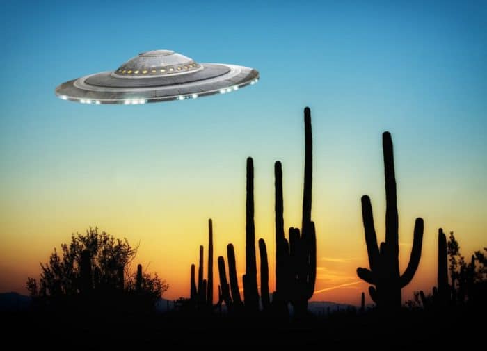 A depiction of a UFO over the desert