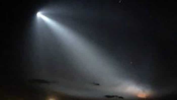 A depiction of a UFO shining a bright light