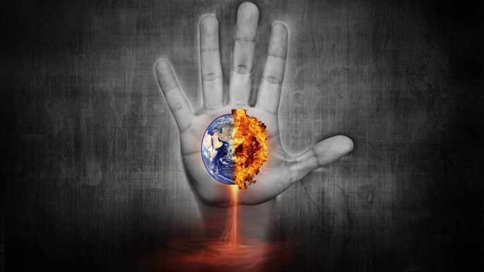 Picture of a single hand with an exploding Earth in the palm