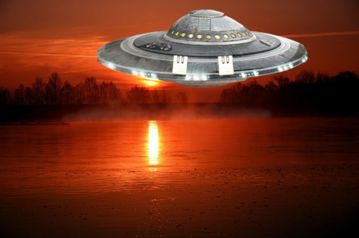 A depiction of a UFO over a river at sunset 