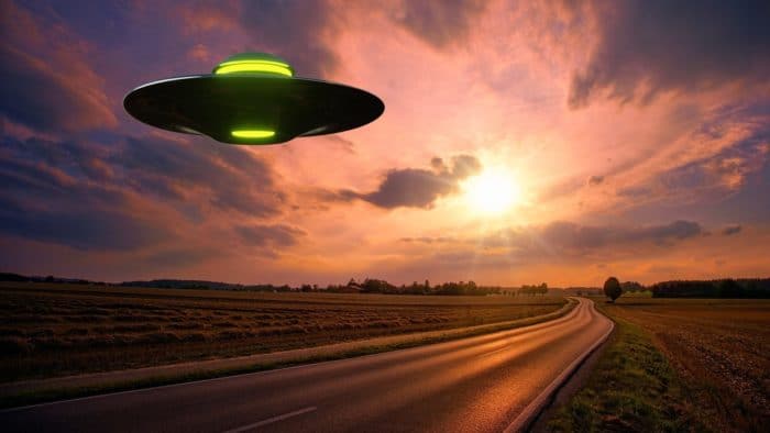 A superimposed UFO over a lonely highway