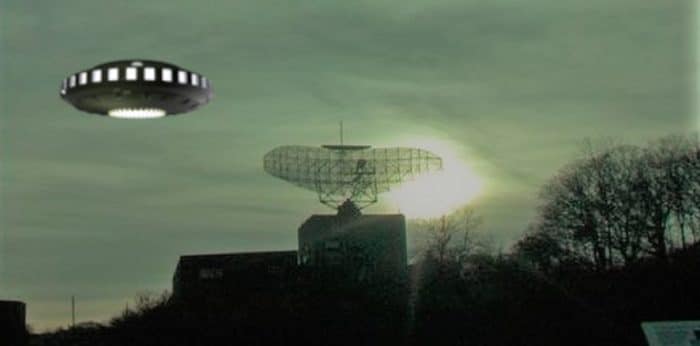 A depiction of a UFO over a radio tower