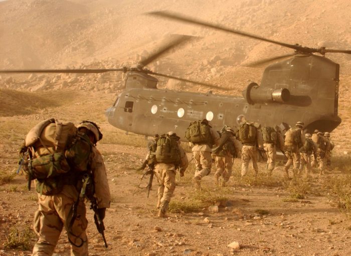 American military personnel boarding a helicopter in the middle east