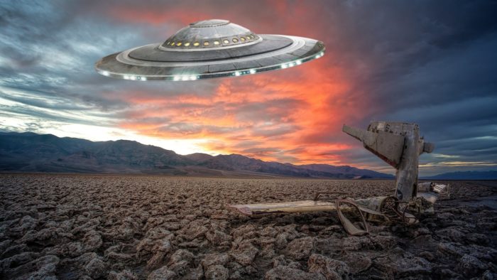 An image of a UFO over a stony ground at sunset