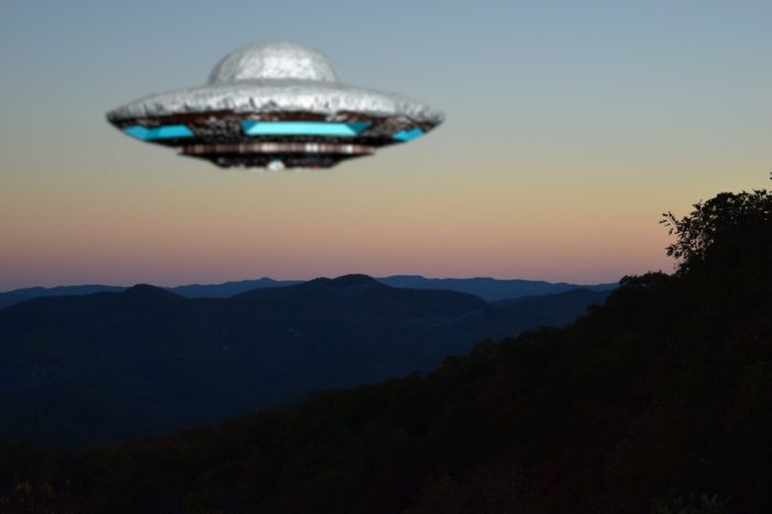 A UFO superimposed over a scene of mountains