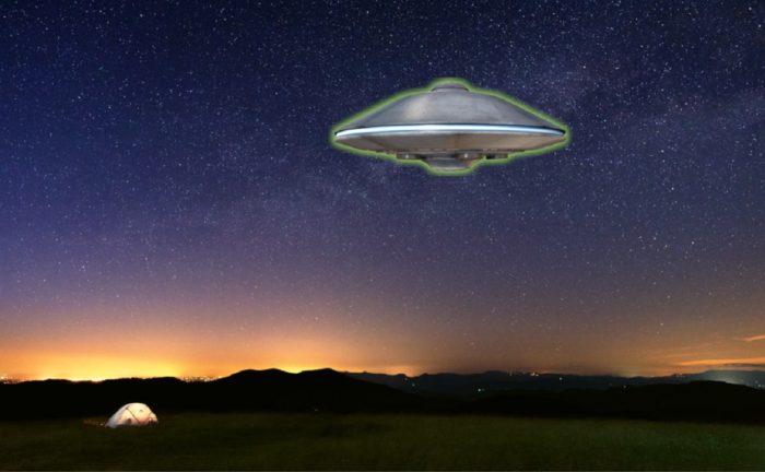 A picture of a UFO hovering over a field 