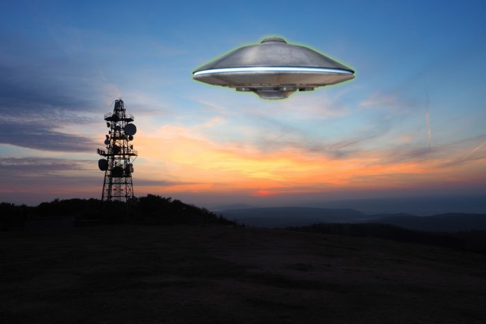 A depiction of a UFO over a radio tower 