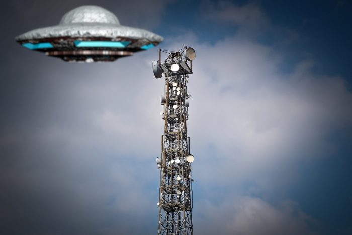 A depiction of a UFO over a radio tower