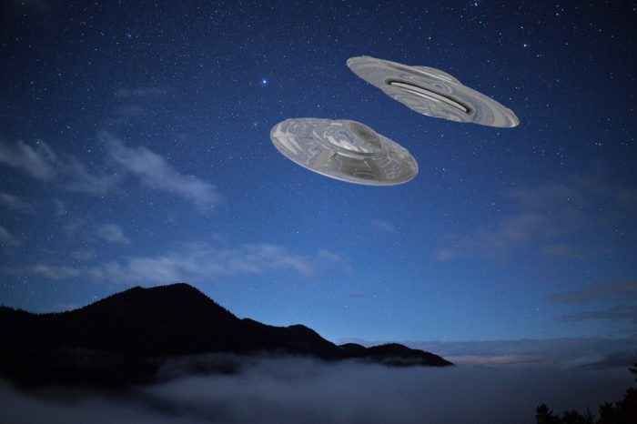 A superimposed UFO over a night mountain scene