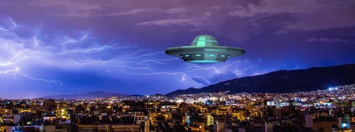 A superimposed UFO over a city at night