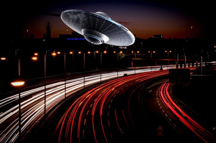 A superimposed UFO over a highway at night 