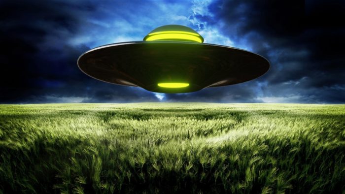 A depiction of a UFO over a field at night