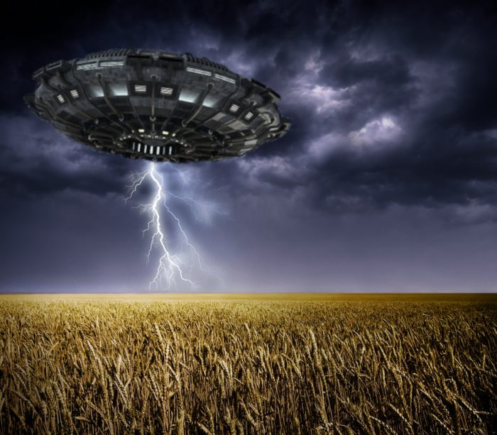 A depiction of a UFO over a wheat field 