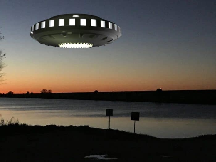 A UFO superimposed onto a picture of a lake at dusk 