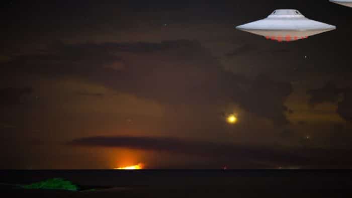 A superimposed UFO over a field at night