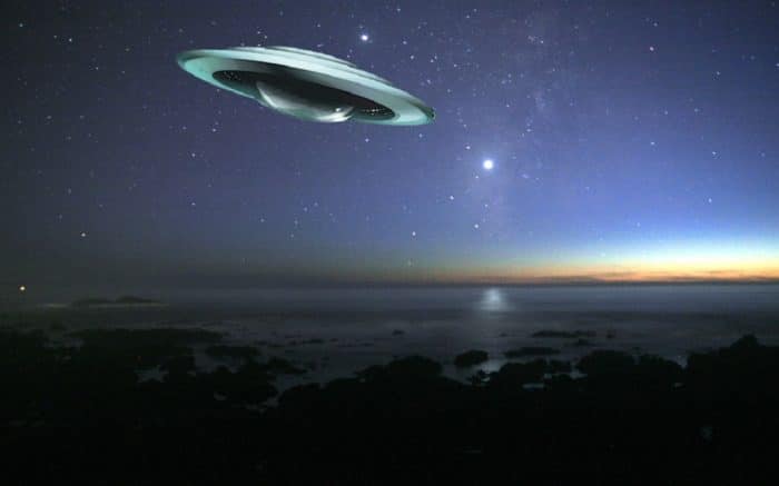 A superimposed UFO over a night coast 